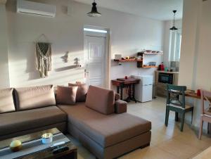 a living room with a couch and a kitchen at Studio Melissi Korinthias in Melíssion