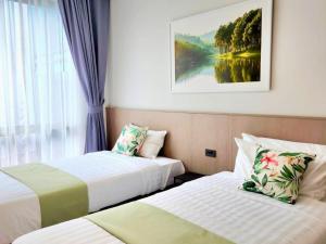 una camera d'albergo con due letti e una finestra di Sand Dance Hotel a Prachuap Khiri Khan