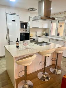 a kitchen with a counter with two bar stools at SeaHomes Vacations - NAUTIC MARITIME Apt in Blanes