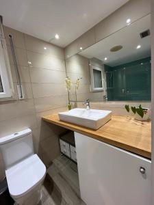 a bathroom with a white sink and a toilet at SeaHomes Vacations - NAUTIC MARITIME Apt in Blanes