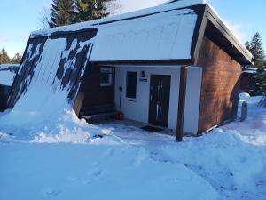 een huis bedekt met sneeuw ervoor bij Guesthouse Danuta in Szklarska Poręba
