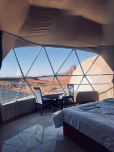 a bedroom with a bed and a view of the desert at wadi rum guest house camp in Aqaba