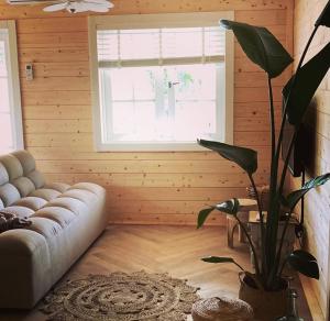 a living room with a couch and a large window at Bed and breakfast de Heg in Geldrop
