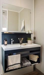 a bathroom with a sink and a mirror at Camping de l'Orangerie de Lanniron in Quimper