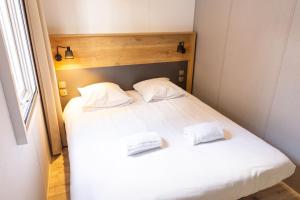 een slaapkamer met 2 bedden met witte lakens en kussens bij Camping de l'Orangerie de Lanniron in Quimper