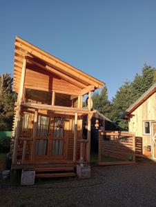 a log cabin with a porch and a fence at Mini Casa en el Sur in San Martín de los Andes