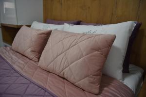 a bed with brown and white pillows on it at SM apartman in Bijeljina
