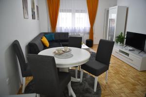 a living room with a table and a couch at SM apartman in Bijeljina