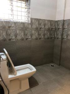a bathroom with a toilet and a shower at Hotel Amulya Regency in Bangalore