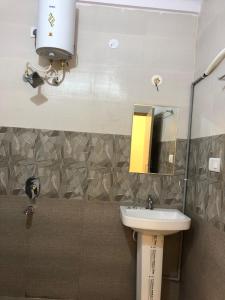 a bathroom with a sink and a mirror at Hotel Amulya Regency in Bangalore