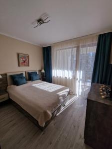 a bedroom with a large bed and a window at Апартамент Лейк Вю, вила Флора, комплекс Маунтин лейк in Smolyan +12 photos
