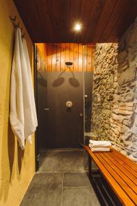 uma casa de banho com um chuveiro e um banco de madeira em Mas Redortra Excepcional masía del SXV con vistas al Montseny em Sant Pere de Torelló