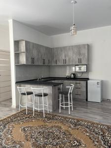 a kitchen with a counter and stools in it at Guest house Simiram in Cholpon-Ata