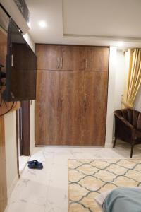 Un dormitorio con armarios de madera y un sofá en una habitación en NuvaHotel, en Islamabad