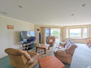 a living room with couches and a flat screen tv at Perfect for lake view and city view in Rotorua in Rotorua