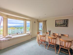 a dining room with a table and a large window at Perfect for lake view and city view in Rotorua in Rotorua