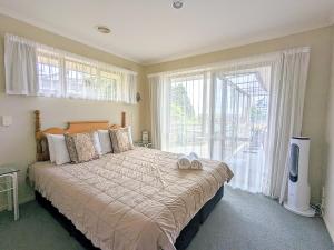 a bedroom with a bed with two shoes on it at Perfect for lake view and city view in Rotorua in Rotorua