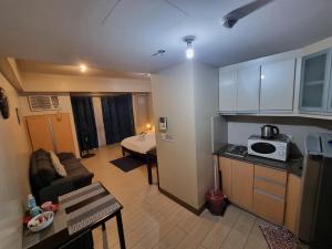 um pequeno apartamento com uma cozinha e uma sala de estar em Palm Tree Condos near MNL Airport Terminal 3 by ELR em Manila