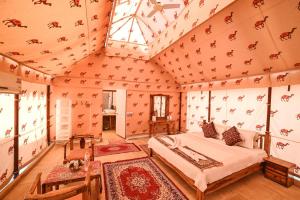 斋沙默尔Lakhmana Desert Camp With Swimming Pool的一间卧室，里面有一张床，天花板上有动物