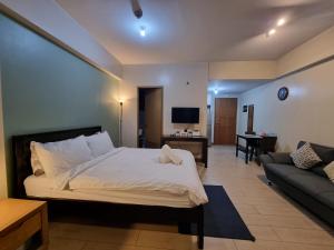 a bedroom with a bed and a living room with a couch at Palm Tree Condos near MNL Airport Terminal 3 by ELR in Manila