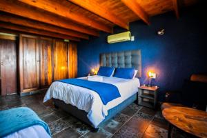 a bedroom with a large bed with blue walls at Koraalboom at Benlize in Hartbeespoort