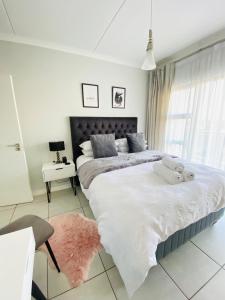 1 dormitorio con cama grande y alfombra rosa en Deluxe one bedroom at the Blyde crystal lagoon, en Pretoria