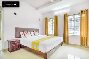 a bedroom with a large bed with yellow curtains at Mistyplanet vagamon in Vagamon