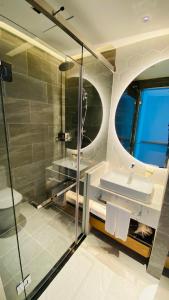 a bathroom with a shower and a sink and a mirror at SIHA Hotel & Casino in Sihanoukville