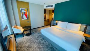 a hotel room with a large bed and a chair at SIHA Hotel & Casino in Sihanoukville