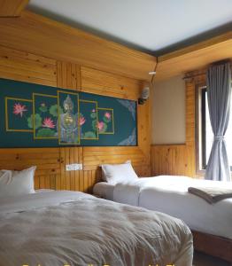 Hotel Grand Shambala في Muktināth: سريرين في غرفة بجدران خشبية