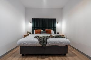 a bedroom with a large bed with a black headboard at Apartamenty Przełom Białki - plac zabaw, wiata grillowa in Białka Tatrzanska
