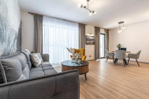 a living room with a couch and a table at Apartamenty Przełom Białki - plac zabaw, wiata grillowa in Białka Tatrzanska