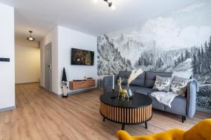 a living room with a couch and a table at Apartamenty Przełom Białki - plac zabaw, wiata grillowa in Białka Tatrzanska