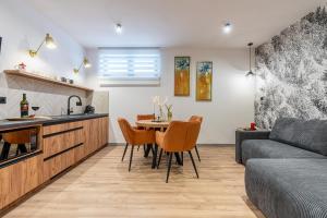 a kitchen and living room with a table and chairs at Apartamenty Przełom Białki - plac zabaw, wiata grillowa in Białka Tatrzanska