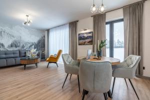 a living room with a table and chairs and a couch at Apartamenty Przełom Białki - plac zabaw, wiata grillowa in Białka Tatrzanska