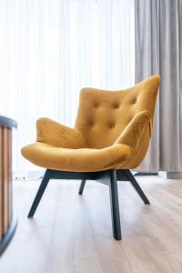 a yellow chair sitting in front of a window at Apartamenty Przełom Białki - plac zabaw, wiata grillowa in Białka Tatrzanska