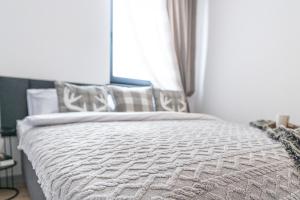a bedroom with a white bed with a window at Apartamenty Przełom Białki - plac zabaw, wiata grillowa in Białka Tatrzanska