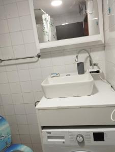 ein Badezimmer mit einem weißen Waschbecken und einem Spiegel in der Unterkunft Sunshine apartment near the zoo, free parking in Sarajevo
