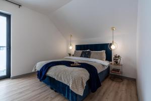 a bedroom with a blue bed and white walls at Apartamenty Przełom Białki - plac zabaw, wiata grillowa in Białka Tatrzanska +37 photos