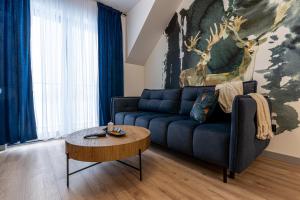 a living room with a blue couch and a table at Apartamenty Przełom Białki - plac zabaw, wiata grillowa in Białka Tatrzanska