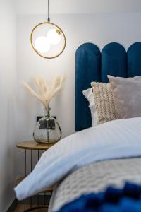 a bed with a blue headboard and a table at Apartamenty Przełom Białki - plac zabaw, wiata grillowa in Białka Tatrzanska
