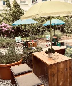 a patio with tables and chairs with an umbrella at beans parc hotel jade in Wilhelmshaven