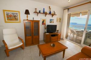 sala de estar con TV, sofá y silla en APARTAMENTO "Mis tesoros", en Calpe