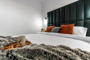a bed with a tray with a coffee cup on it at Apartamenty Przełom Białki - plac zabaw, wiata grillowa in Białka Tatrzanska