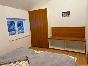 1 dormitorio con 1 cama y armario de madera en Haus Edelweiss, en Obertraun