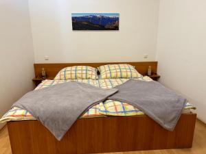 een bed met een deken erop in een slaapkamer bij Haus Edelweiss in Obertraun