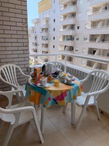 uma mesa e cadeiras numa varanda com comida em Marina Trébol Playa em Oropesa del Mar