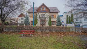 a red park bench in front of a house at Pension Bavaria in Braşov