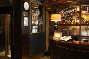 eine Bar mit einer Uhr und einem Schreibtisch mit einem Telefon in der Unterkunft Tralee Benners Hotel in Tralee