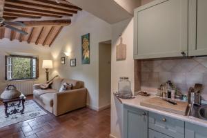 een keuken en een woonkamer met een bank en een tafel bij Borgo Al Cerro in Casole dʼElsa